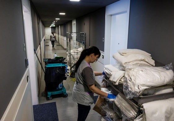Una camarera de piso, limpiando las habitaciones de un hotel.