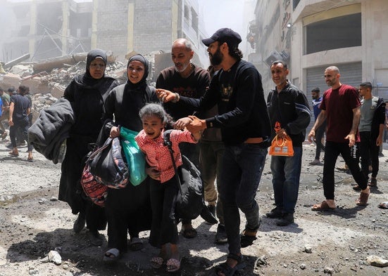 Una familia palestina huye con sus escasas pertenencias tras un bombardeo israelí en Gaza.