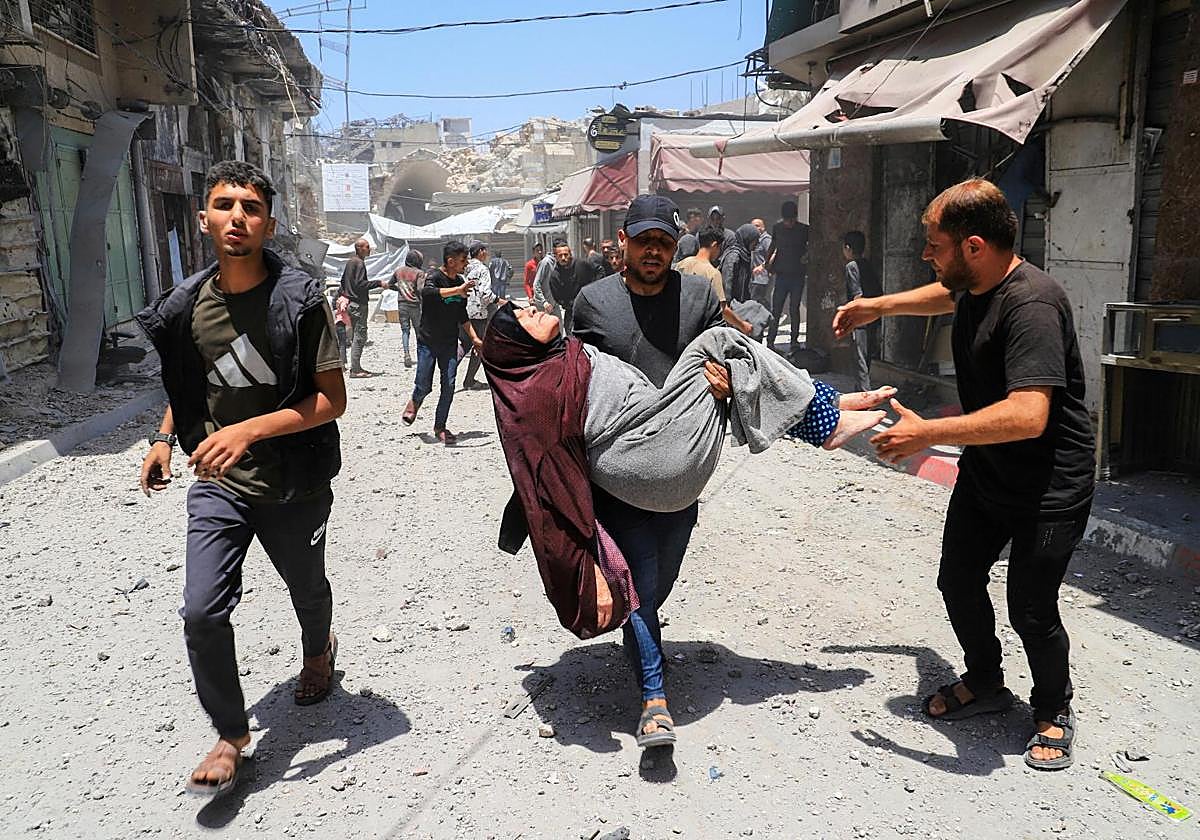 Un ciudadano de Gaza lleva en brazos a una mujer herida durante un ataque del ejército de Israel.