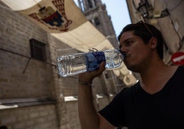Un joven se refresca en Toledo.