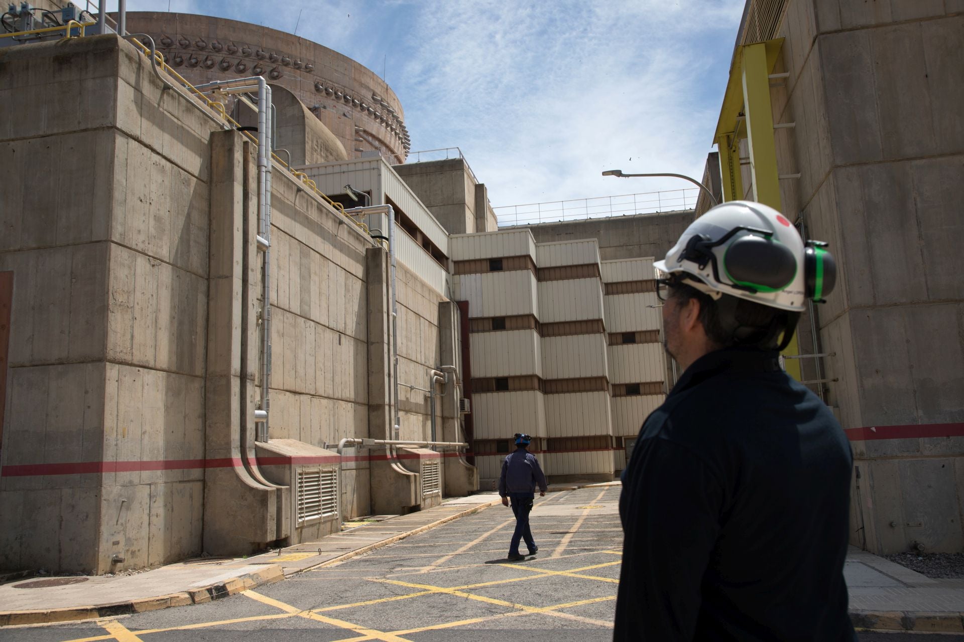Un empleado frente al edificio de contención y el recinto auxiliar.