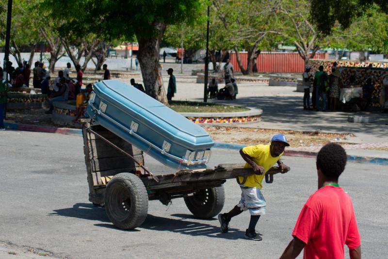 Un hombre traslada el ataúd de una víctima de las pandillas por una calle de Puerto Príncipe.
