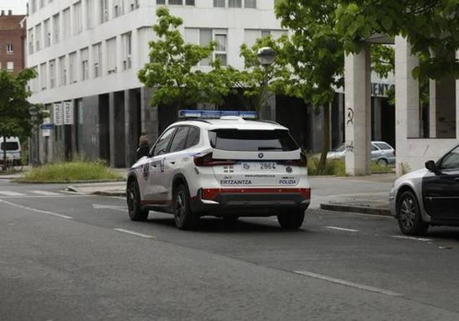 Un coche patrulla custodia el acceso a uno de los dos pisos registrados por la Ertzaintza en Vitoria.