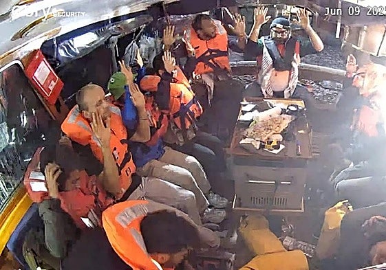 Activistas desde el barco con las manos arriba.