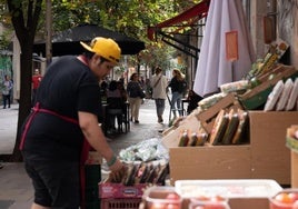 Un dependiente coloca fruta en un pequeño comercio.