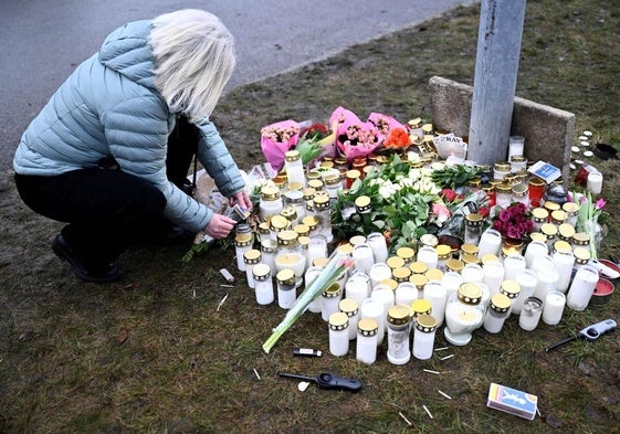 Una mujer enciende una vela en un altar en recuerdo a las víctimas del tiroteo en Suecia el pasado 4 de febrero.