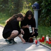 Dos estudiantes rinden homenaje a los alumnos asesinados en el exterior del colegio.