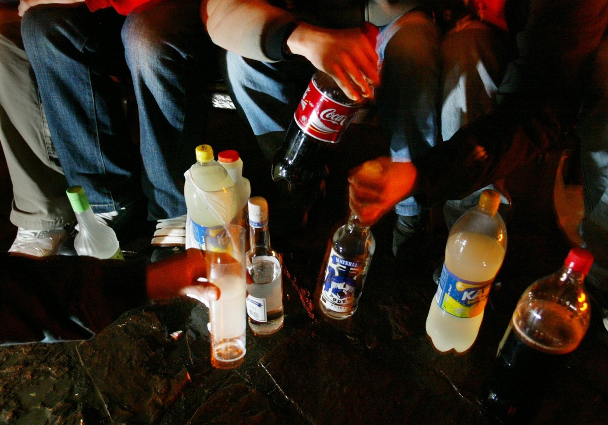 Un grupo de jóvenes participa en un botellón en un parque.