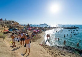 Bañistas disfrutan en la Cala Conta, en Ibiza, Baleares (España)