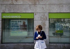 Una mujer frente a una sucursal de Novo Banco en Lisboa.