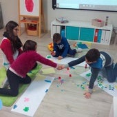 Una monitora y unos niños trabajan en un centro de atención temprana.