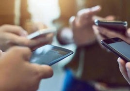 Varios jóvenes utilizando el móvil