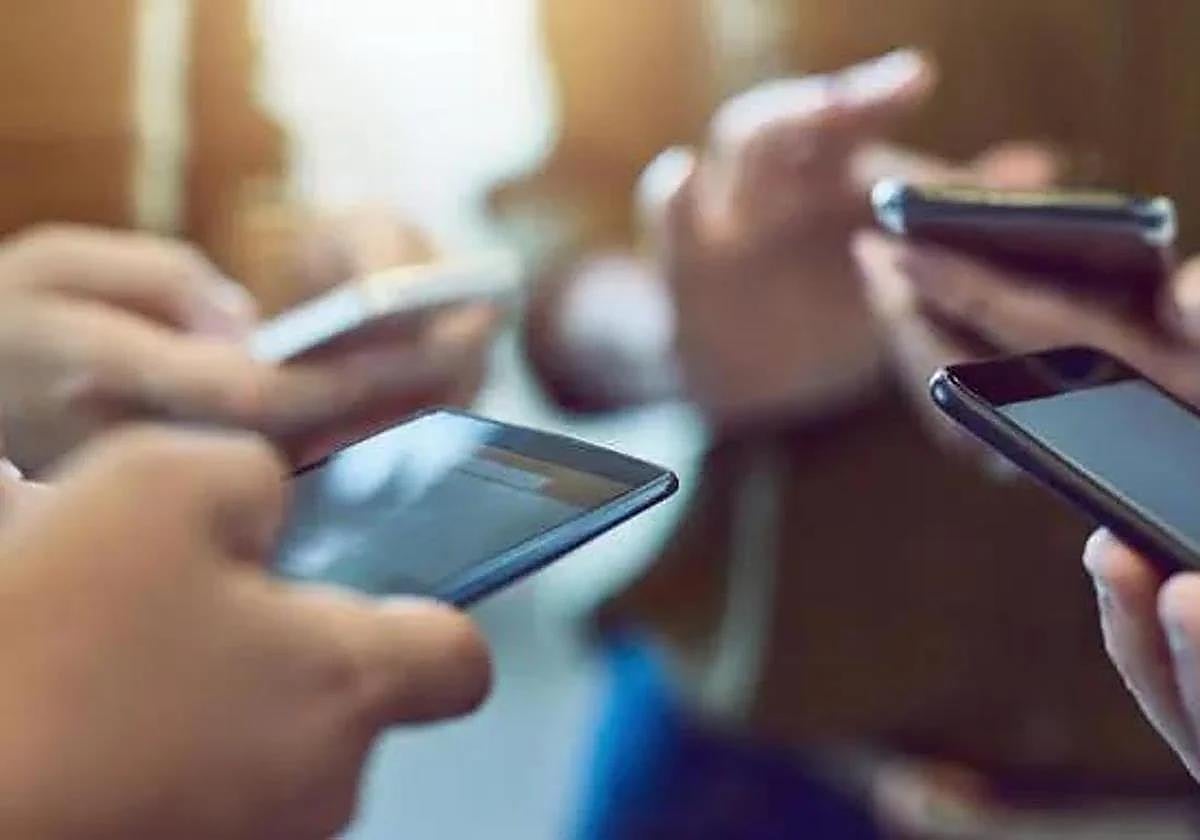 Varios jóvenes utilizando el móvil