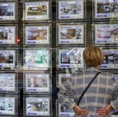 Una mujer mira anuncios en una inmobiliaria.