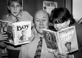 Roald Dahl, consagrado por sus obras infantiles y juveniles, junto a dos jóvenes lectores.