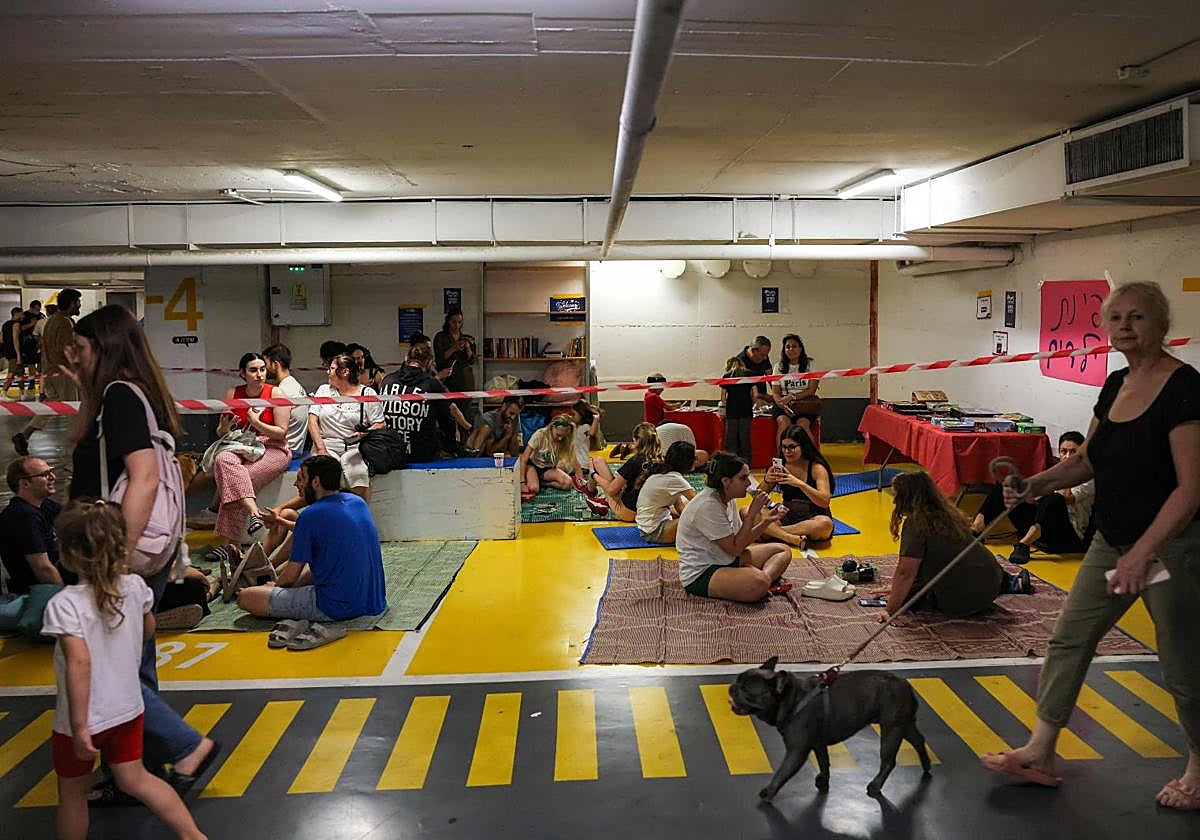 Ciudadanos israelíes refugiados en un aparcamiento en Tel Aviv durante un bombardeo.