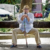Raúl García Losada posa en un parque de Vallecas con la garrota gitana con los colores azul, rojo y verde de la bandera romaní.