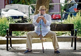 Raúl García Losada posa en un parque de Vallecas con la garrota gitana con los colores azul, rojo y verde de la bandera romaní.
