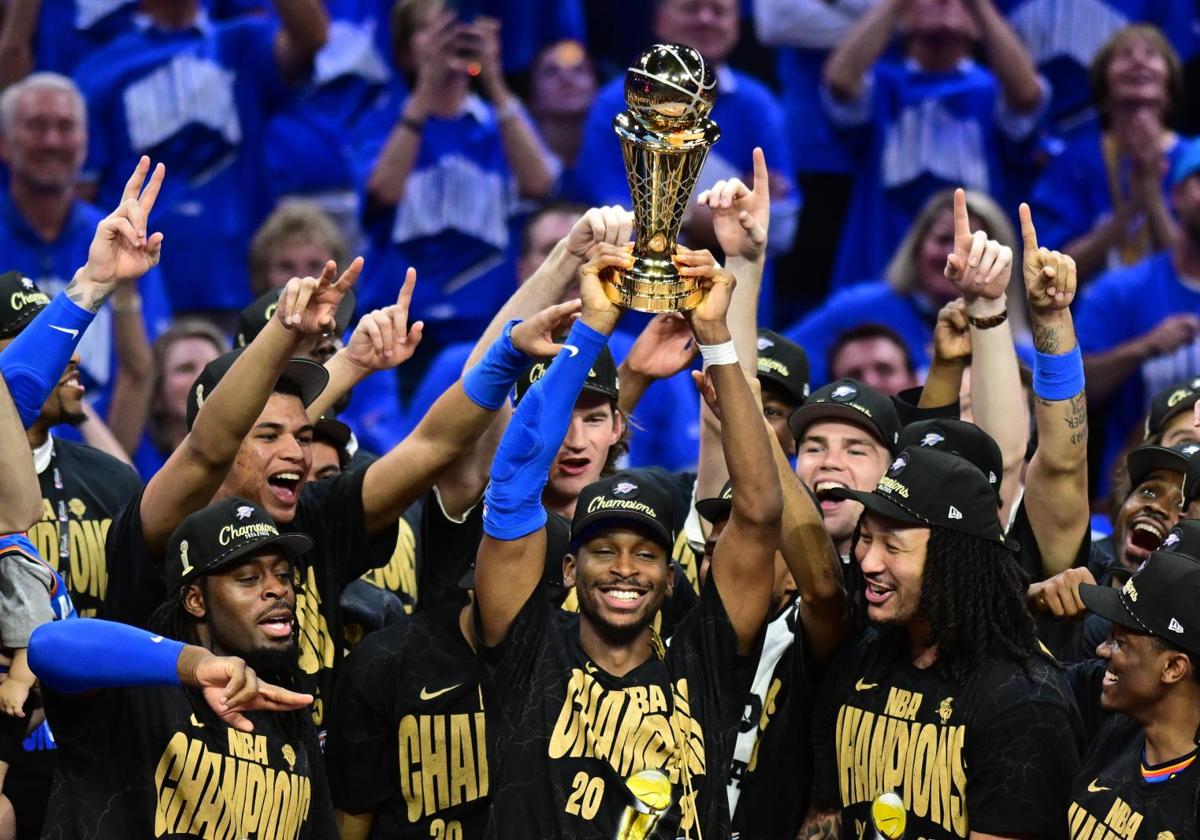 Shai Gilgeous-Alexander lifts the NBA championship trophy