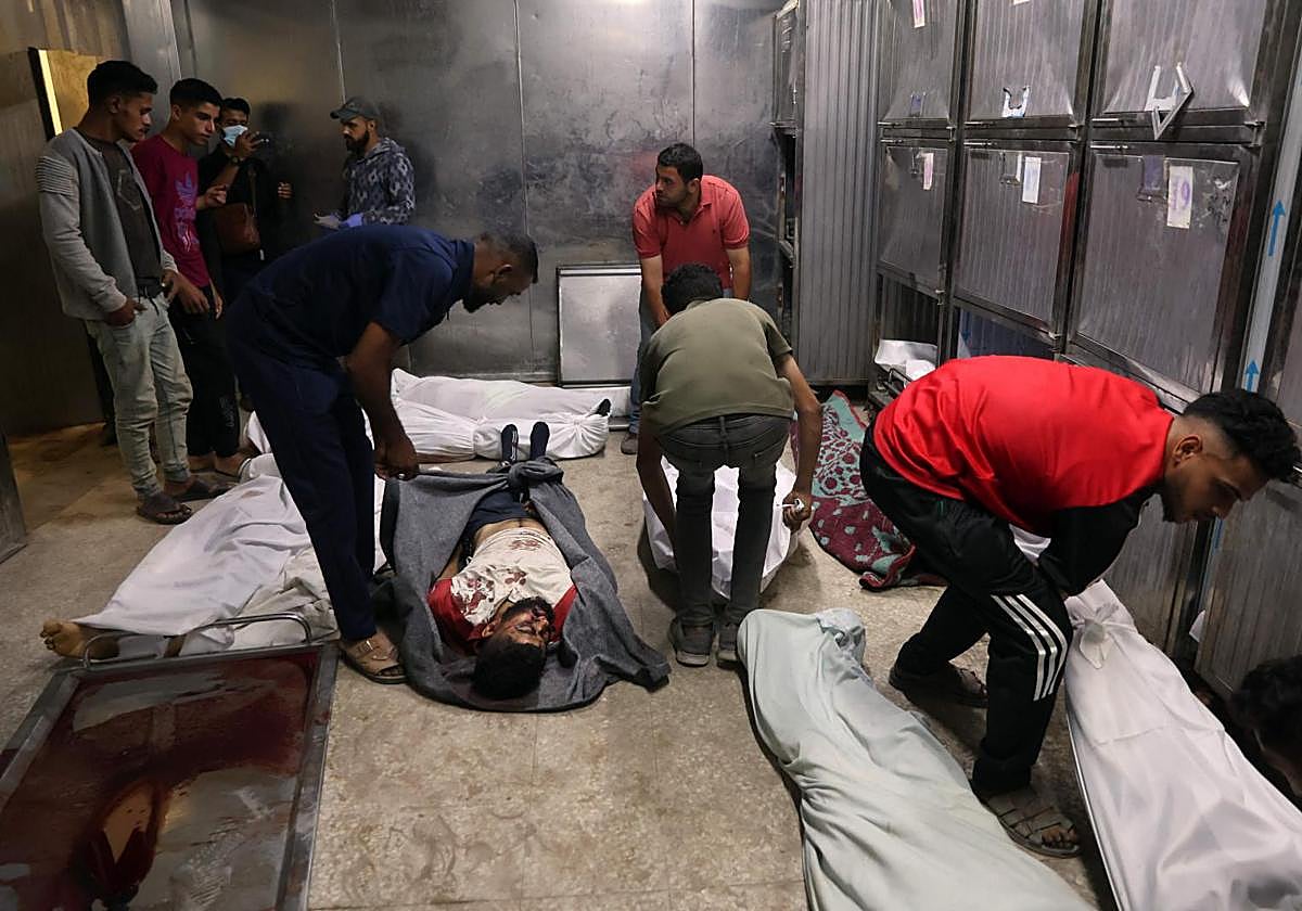 Palestinos identifican los cadáveres de fallecidos por ataques israelíes contra centros de ayuda en Gaza.