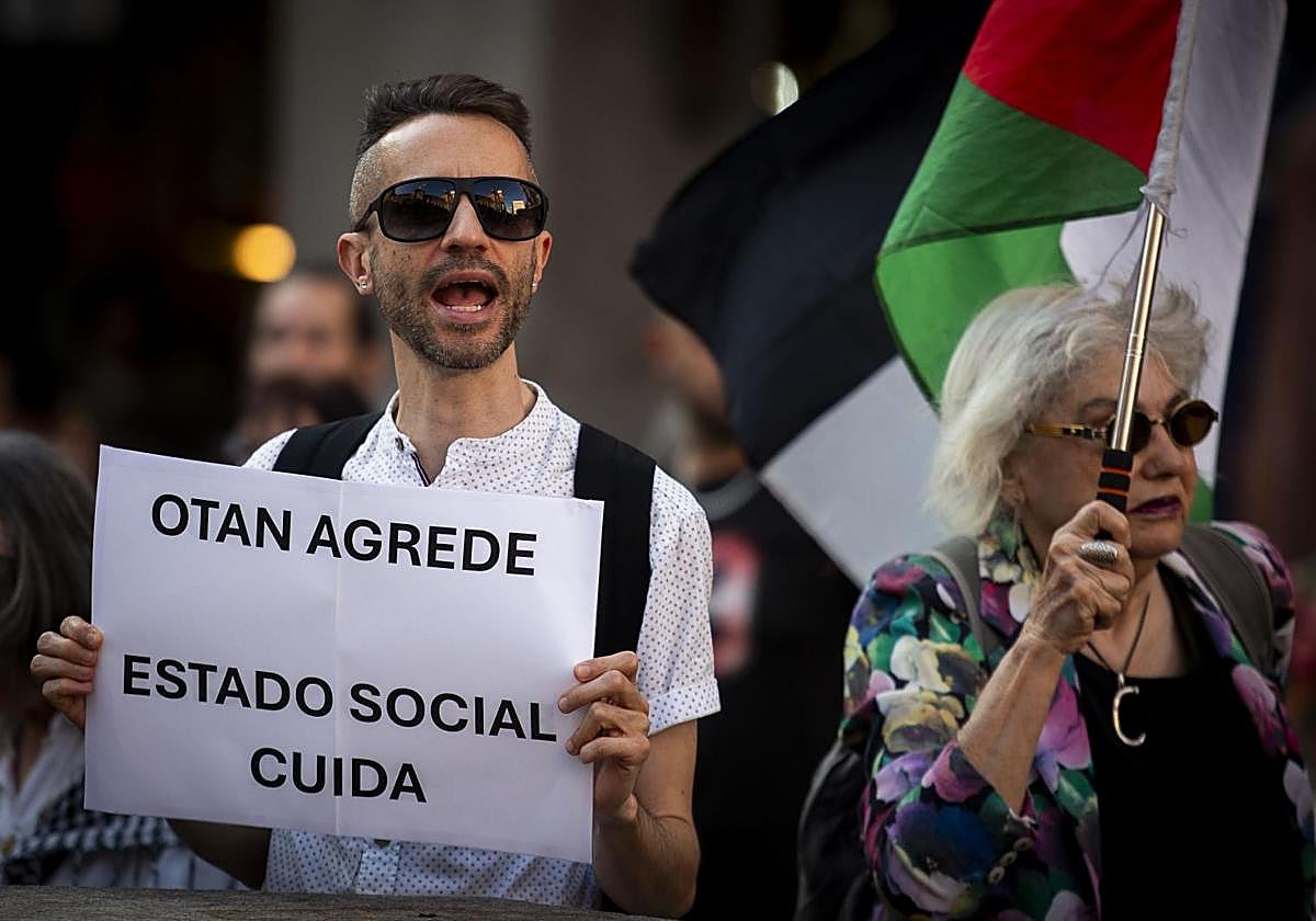 Un grupo de personas se manifiestan en Madrid contra el aumento del gasto militar en la OTAN.