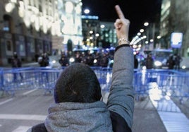 Un manifestante hace un gesto despectivo a la Policía en una protesta ante el Congreso.