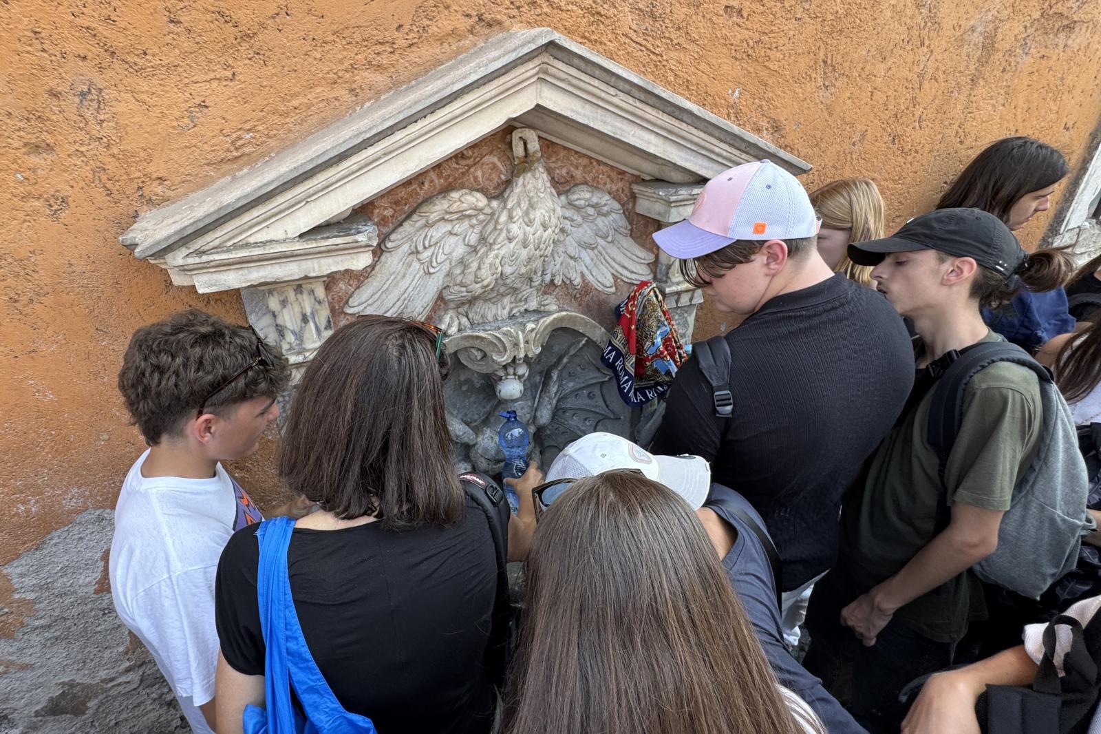 Un grupo de turistas en una fuente de Roma.