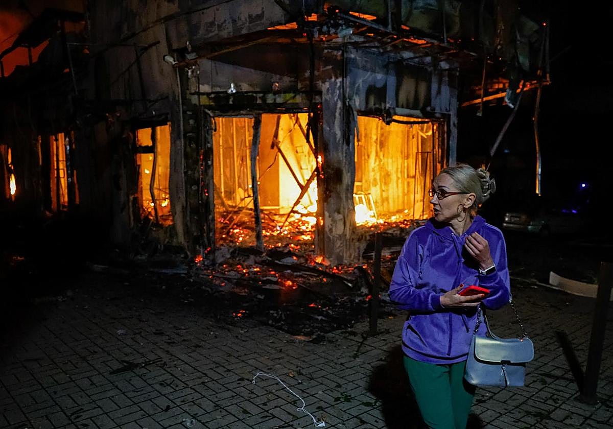 Una mujer camina frente a un mercado afectado por un reciente bombardeo en Donetsk.