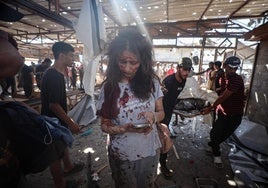 Una mujer palestina herida mira su teléfono móvil en una cafetería de Ciudad de Gaza bombardeada por el ejército israelí.