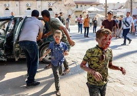 Dos niños palestinos heridos en un ataque israelí corren hacia un hospital en Ciudad de Gaza.