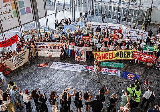Miembros de organizaciones civiles protestan este jueves en la cumbre de la ONU de Sevilla por la cancelación de la deuda a los países en vías de desarrollo.