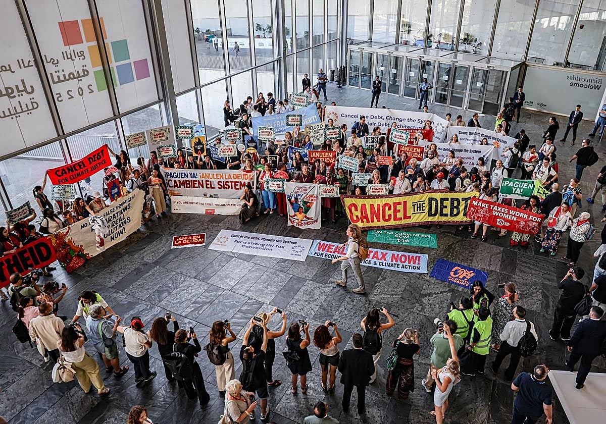 Miembros de organizaciones civiles protestan este jueves en la cumbre de la ONU de Sevilla por la cancelación de la deuda a los países en vías de desarrollo.