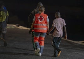 Una trabajadora de Cruz Roja, con un menor migrante en la isla de El Hierro.