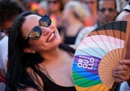 Un mujer ahuyenta el calor con su abanico arcoíris durante el pregón del Orgullo 2025.