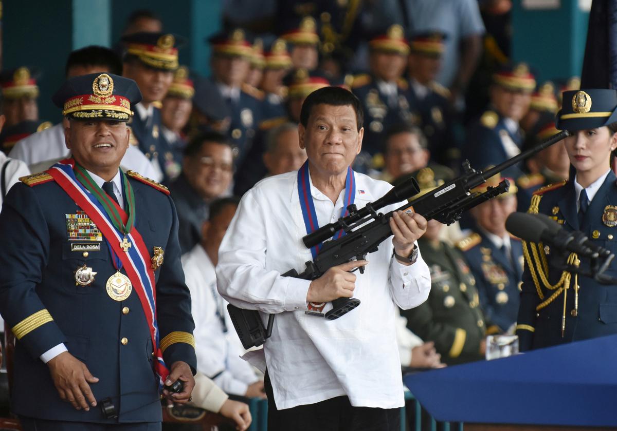 Duterte in 2018, playing with a rifle in front of the press, in Quezon City, near Manila.
