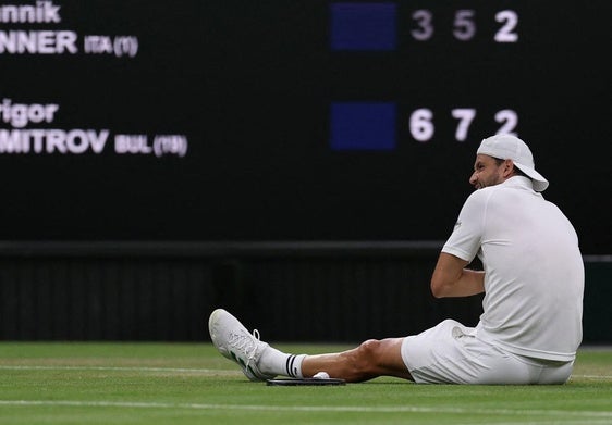 Grigor Dimitrov, roto por el dolor, tiene que sentarse sobre la pista de Wimbledon al no poder continuar este lunes su partido.