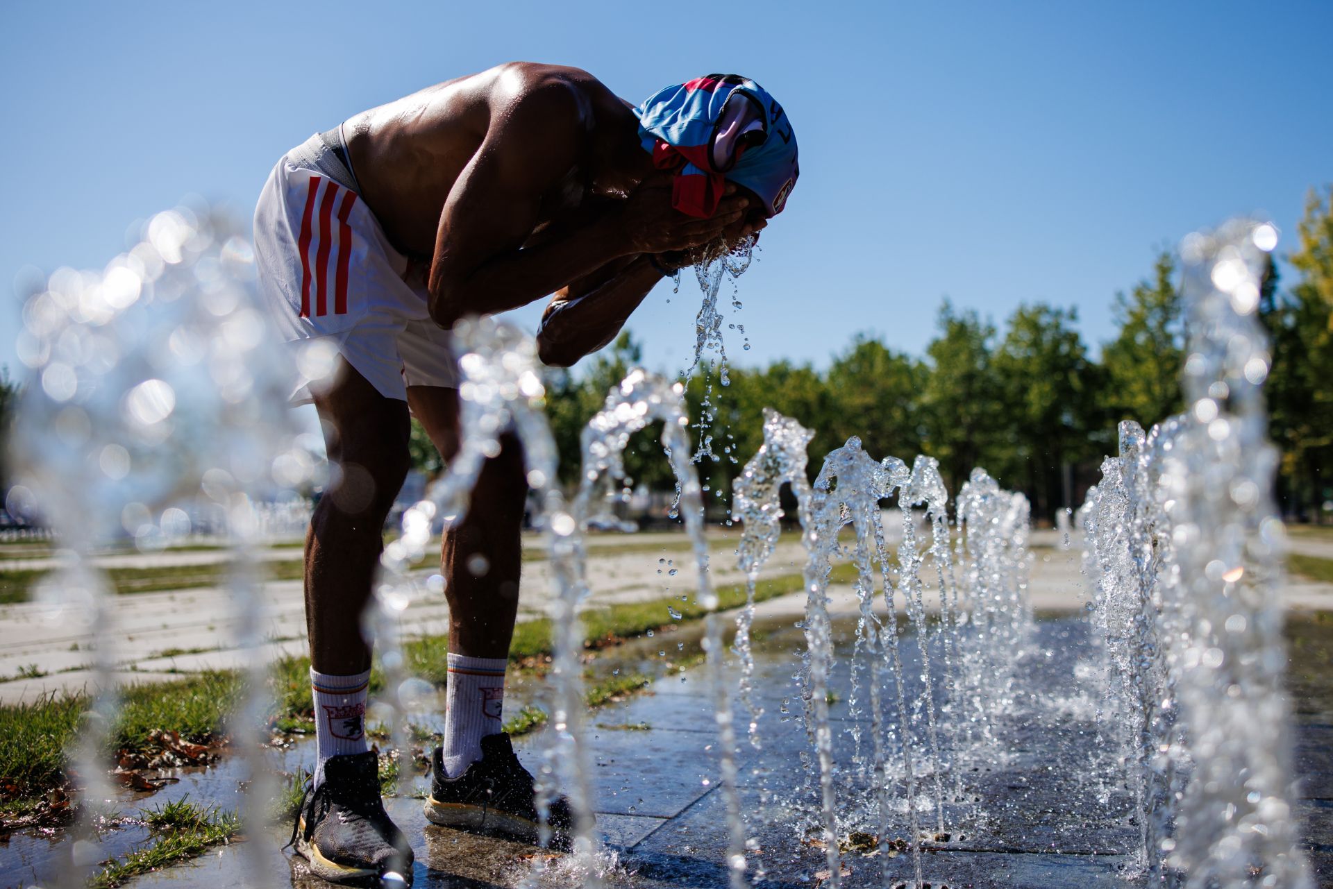 Un transeúnte se refresca en una fuente pública en Alemania durante la última ola de calor.