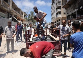 Un hombre traslada a un niño herido tras un bombardeo israelí en Gaza.