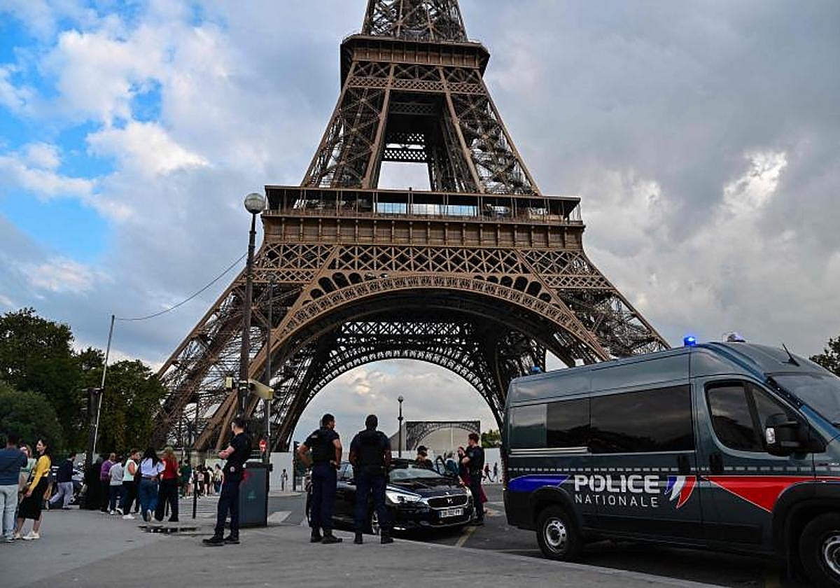 Miembros de la Policía francesa patrullan junto a la Torre Eiffel.