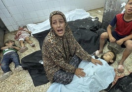 Una mujer llora junto al cadáver de su hijo muerto en un bombardeo israelí en Gaza.