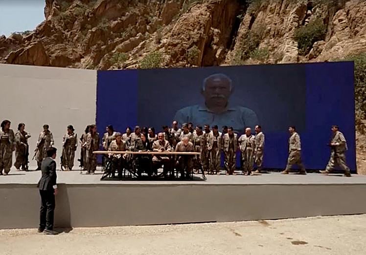 Los militantes durante la ceremonia, delante de un gran retrato de Ocalan.