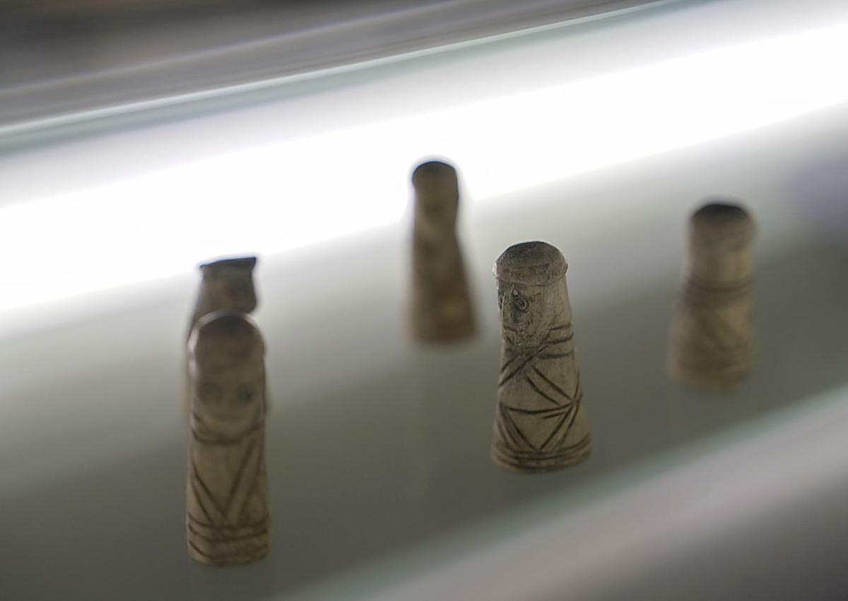 Imagen secundaria 1 - Arriba, vista panorámica del castillo de Mayenne junto al río del mismo nombre. Abajo a la izquierda, piezas de ajedrez talladas entre el siglo X y XII de la extraordinaria colección de juegos de mesa del museo. A la derecha, estatua de Juana de Arco con la basílica de Nuestra Señora de los milagros de fondo.