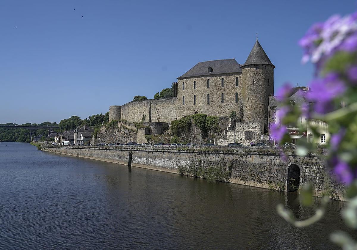 Imagen principal - Arriba, vista panorámica del castillo de Mayenne junto al río del mismo nombre. Abajo a la izquierda, piezas de ajedrez talladas entre el siglo X y XII de la extraordinaria colección de juegos de mesa del museo. A la derecha, estatua de Juana de Arco con la basílica de Nuestra Señora de los milagros de fondo.