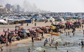 Refugiados del atestado campamento de Al-Malwasi se bañan en la orilla del mar, el único límite tácito que les permite el ejército.