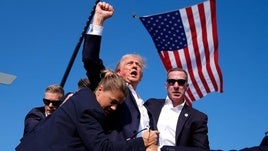 Trump, con la mejilla ensangrentada, es retirado por los agentes del escenario de Butler.