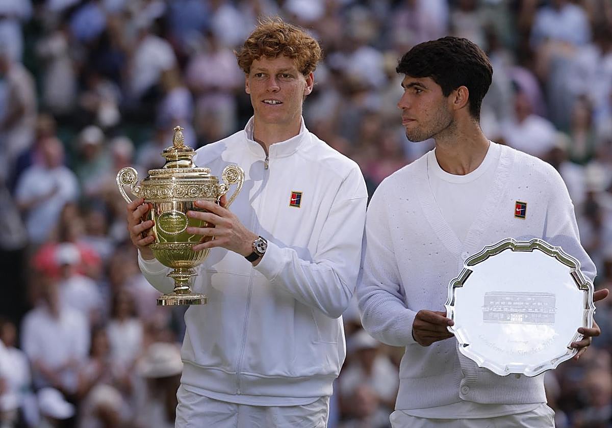 Jannik Sinner y Carlos Alcaraz posan con sus trofeos al término de la final de Wimbledon.