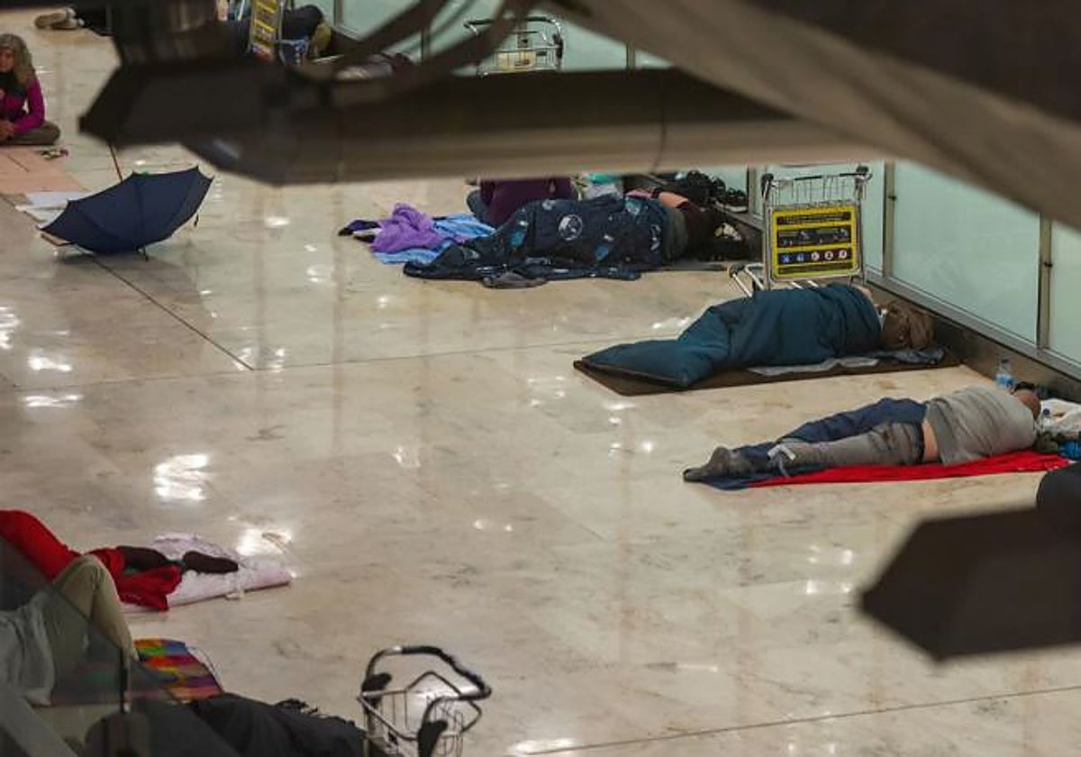 Personas sin hogar duermen en la T4 del aeropuerto de Barajas.