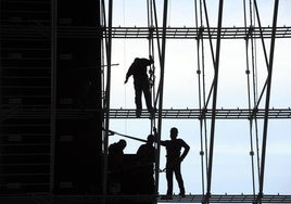 Un grupo de trabajadores, subidos a un andamio.