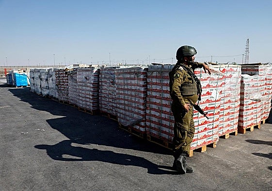 Un militar hebreo custodia un cargamento de ayuda humanitaria fuera de Gaza.