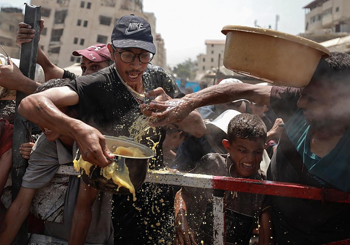 Palestinos reciben raciones de comida en un comedor social en Gaza.